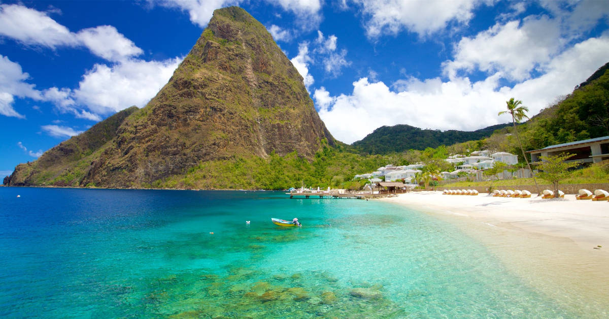 A serene beach with a majestic mountain in the background, offering stunning views for guests at St. Lucia hotels.