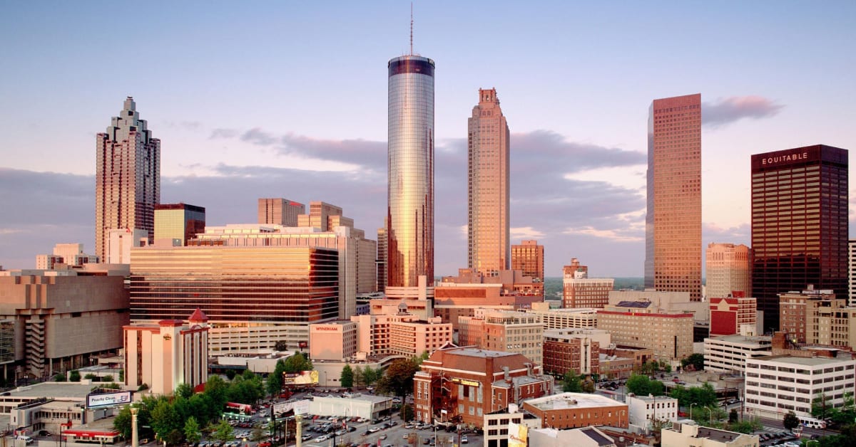 Skyline of a modern city with skyscrapers at dusk, including the best Atlanta hotels.